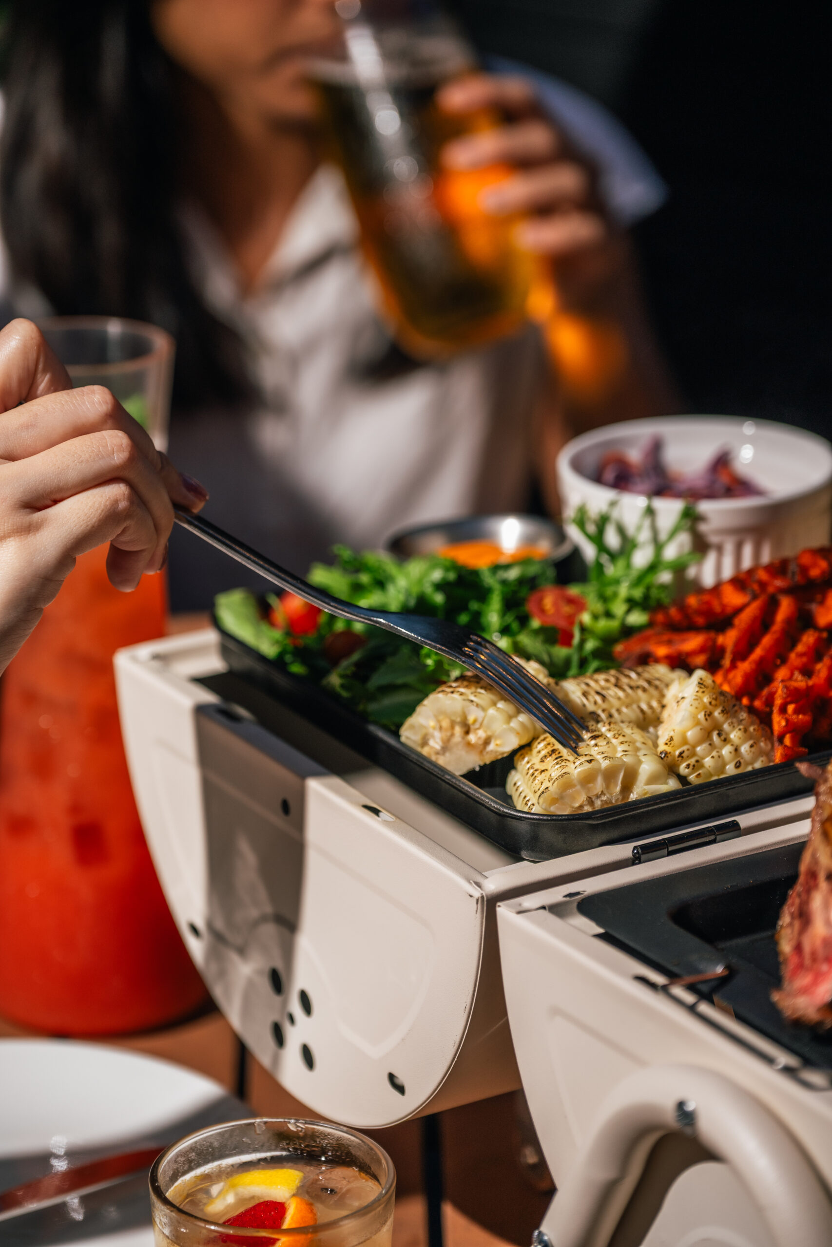 Guest enjoying the 1918 Grill Platter buffet with grilled corn and sides at The Alkaff Mansion Singapore